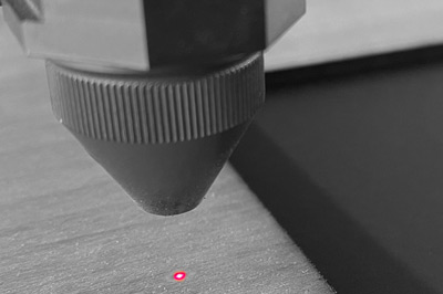 Laserkop van de TROTEC met rode richtpunt op het materiaal